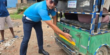 ई–रिक्सामा रिफ्लेक्टिभ स्टिकर टाँस्दै ट्राफिक प्रहरी